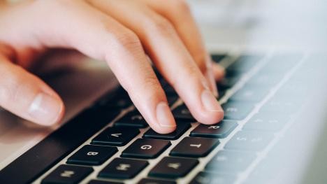Woman typing on a laptop keyboard