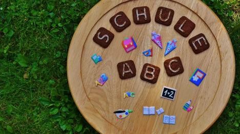 Buchstabenkombination "Schule" auf einem Holzteller