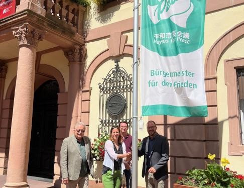 Hebert Köllner, Oberbürgermeisterin Monika Müller, Jonas Weber und Mathias Köppel (von links) hissen gemeinsam die Mayors for Peace Flagge am Historischen Rathaus.