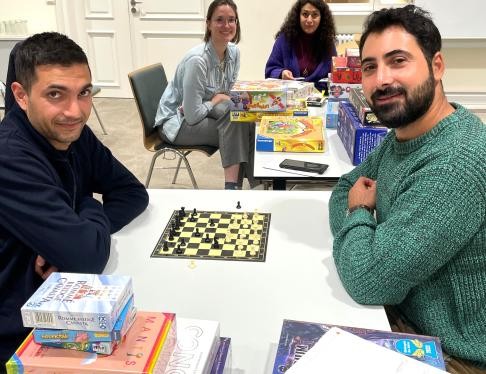 Personen sitzen am Tisch mit Brettspielen