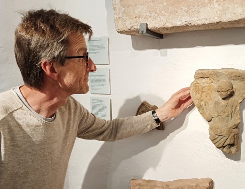 Leiter Zentrales Fundarchivs Dr. Martin Kemkes vor dem Göttinnenrelief im Stadtmuseum.