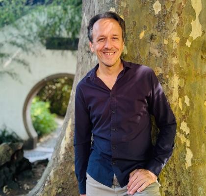 Christof Jauernig Christof Jauernig lächelnd vor einem Baum.