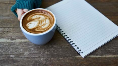 Coffee cup and notepad on a desk