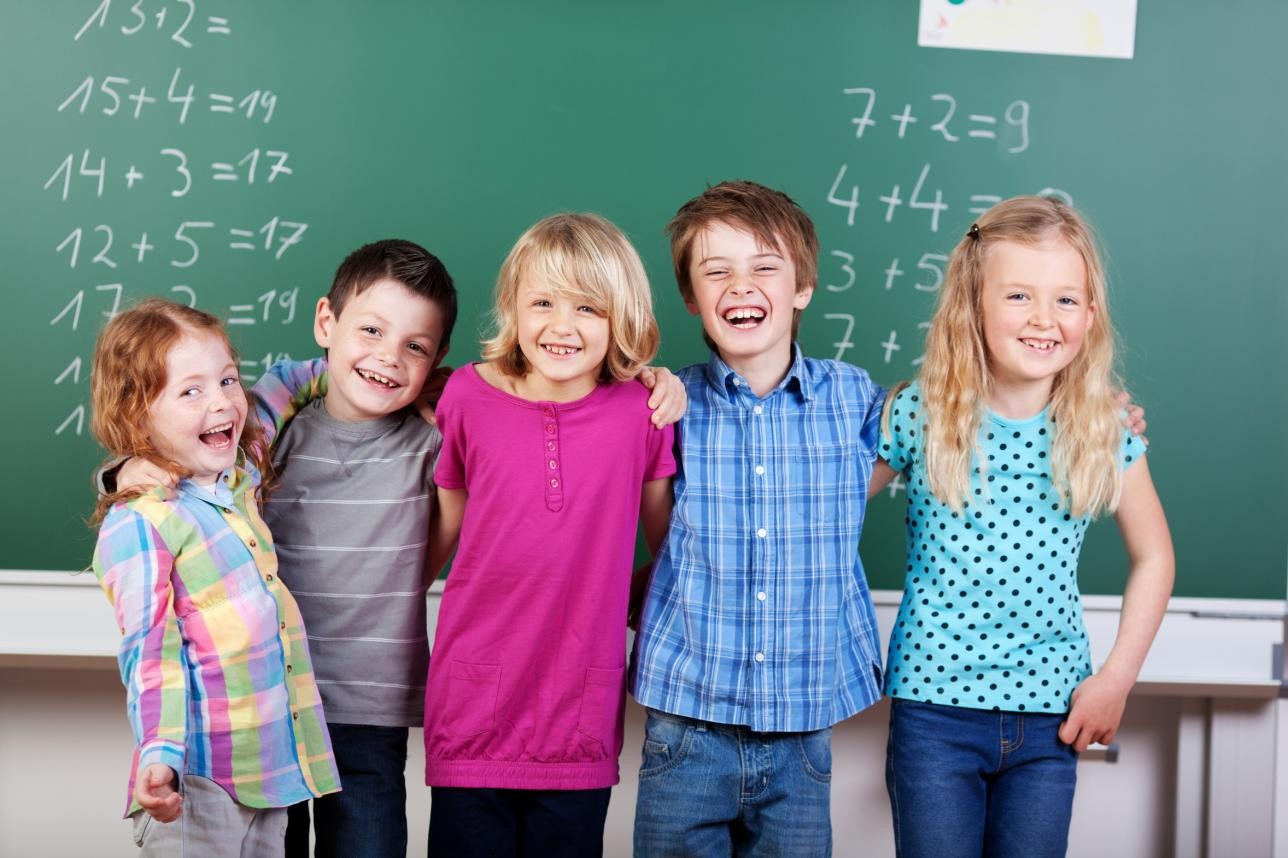 5 enfants devant un tableau d'exercices de mathématiques