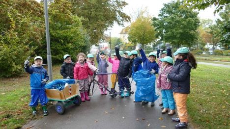 Kinder sammeln Müll an einer Straße in Rastatt ein