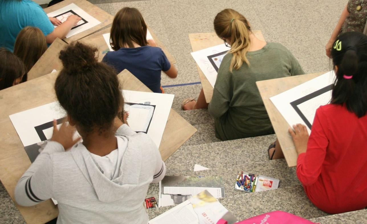 Kreative Auseinandersetzung mit Kunst ist eines der Ziele der Kunstvermittlung , Foto: Eric Schütt. Mehrere Kinder sitzen auf einer Treppe und zeichnen Bilder.