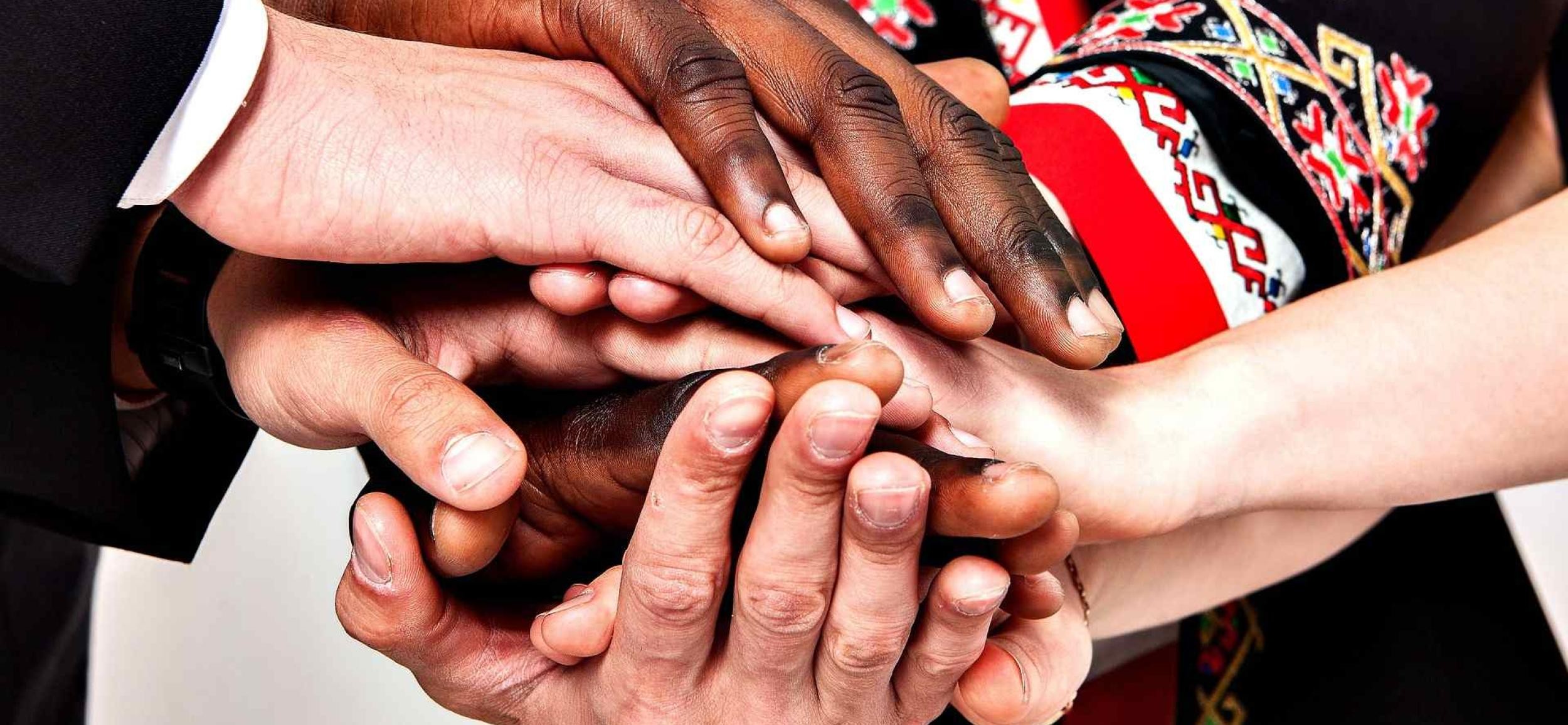 many hands of people from different backgrounds together
