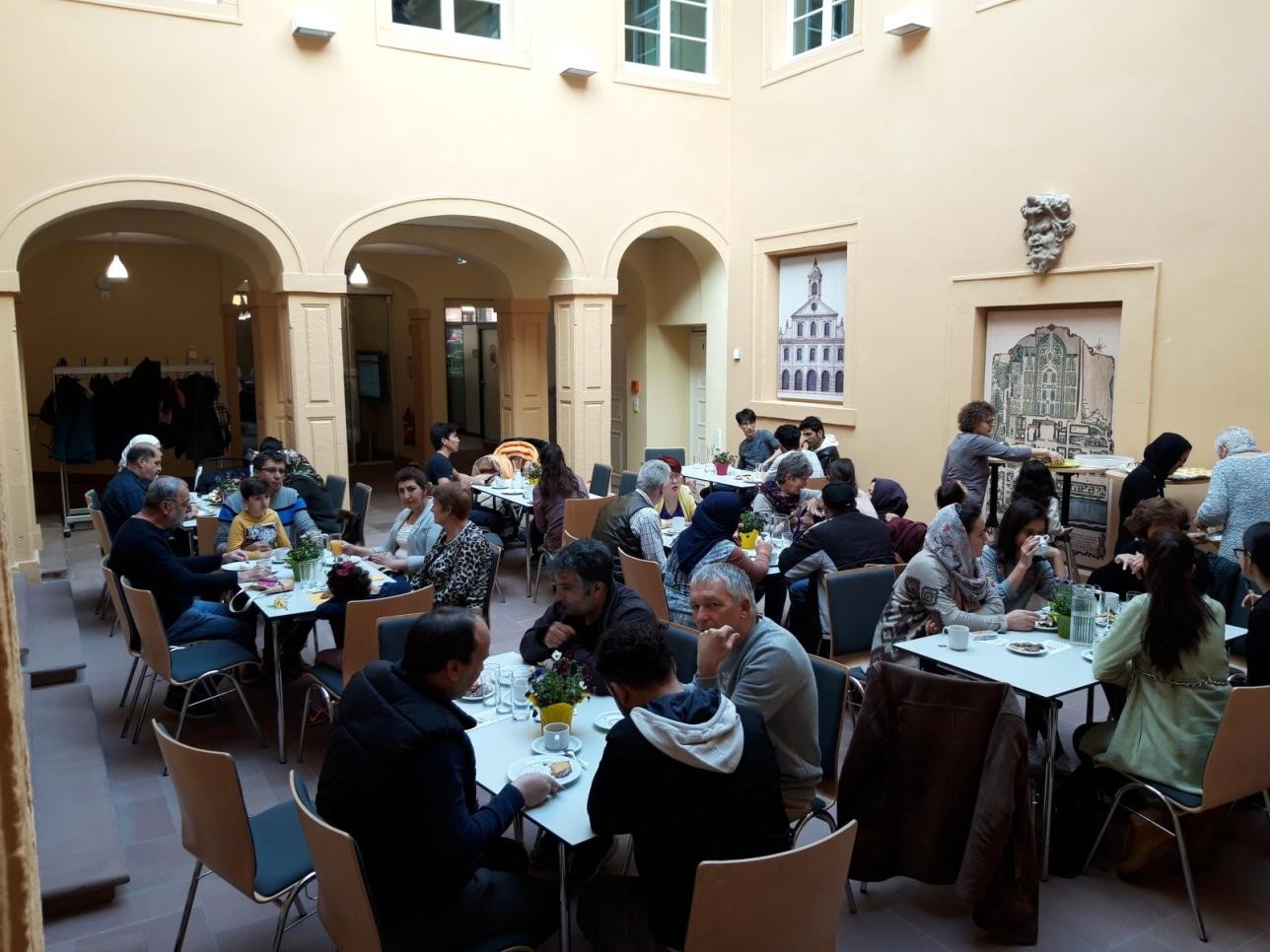 Café International im Rossi-Haus. Foto: Stadt Rastatt Menschen sitzend an Tischen