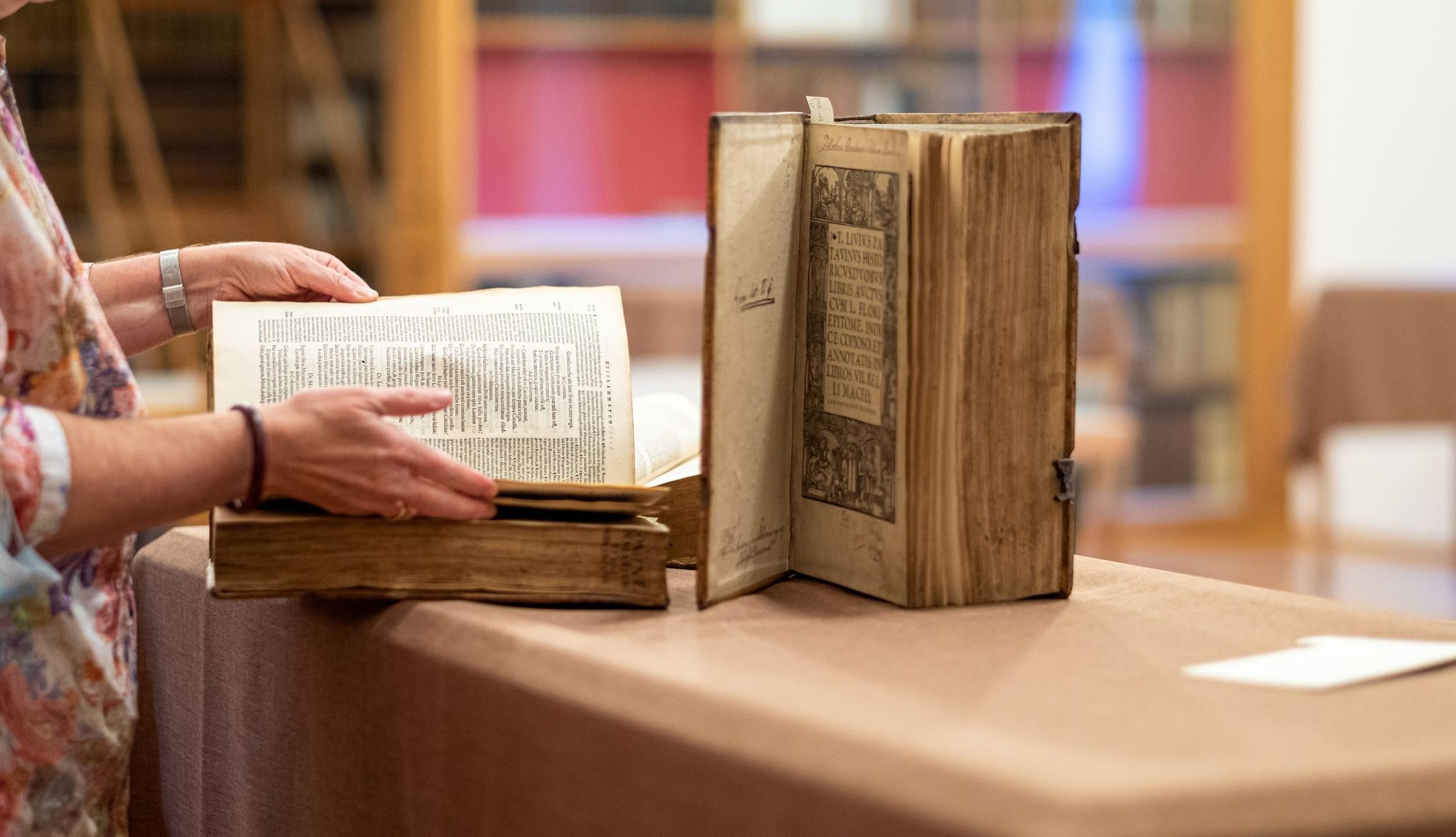 Kostbare alte Bücher werden in der Historischen Bibliothek Rastatt aufbewahrt, Foto: Oliver Hurst. Frau blättert in einem alten Buch in der Historischen Bibliothek Rastatt.