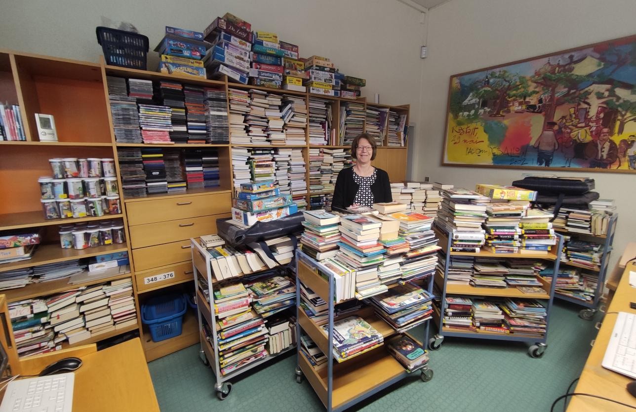 Bibliotheksleiterin Birgitt Stellmach inmitten von Bücherstapeln