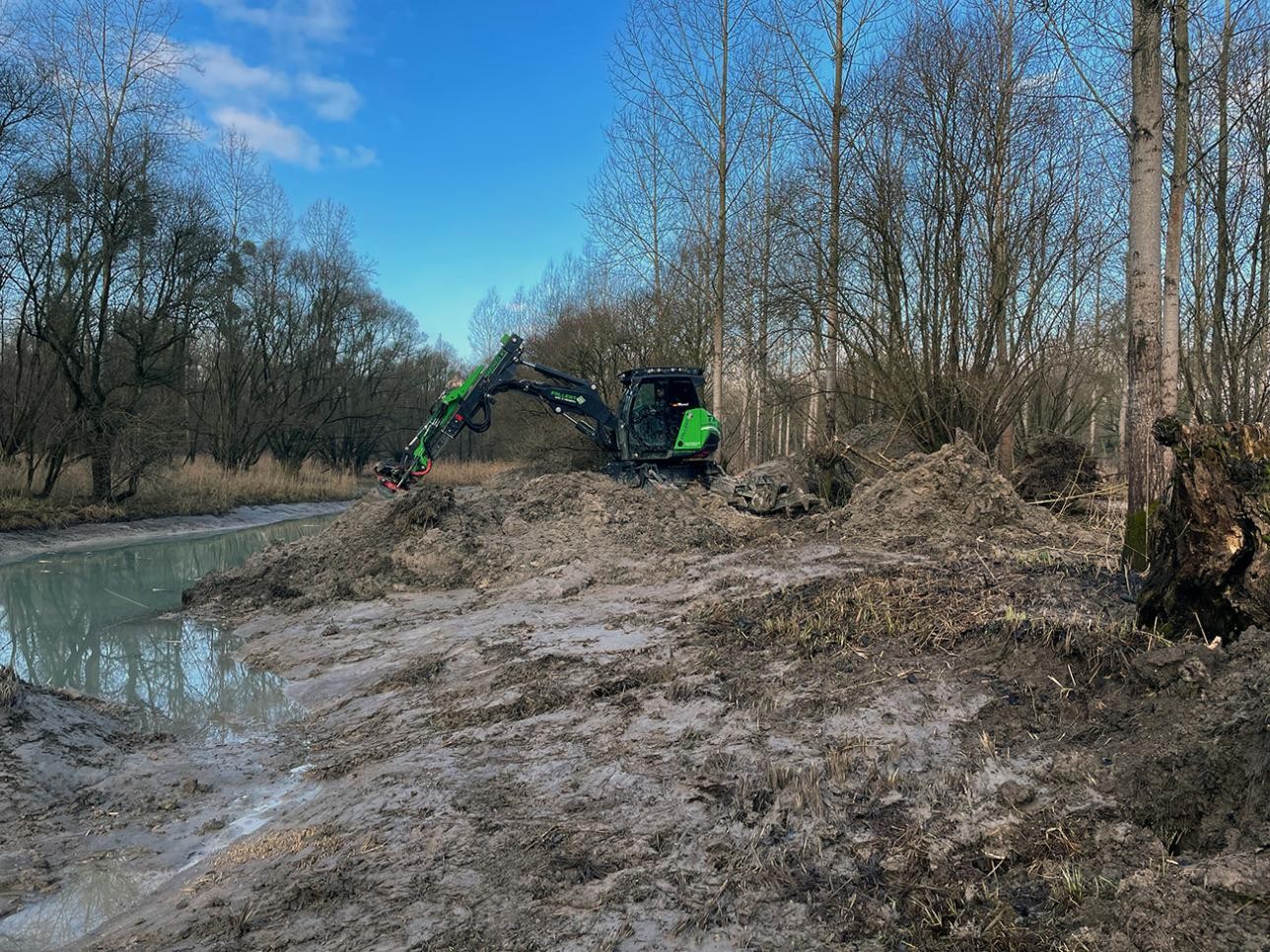 Une pelleteuse continue à creuser une ravine dans les plaines alluviales du Rhin