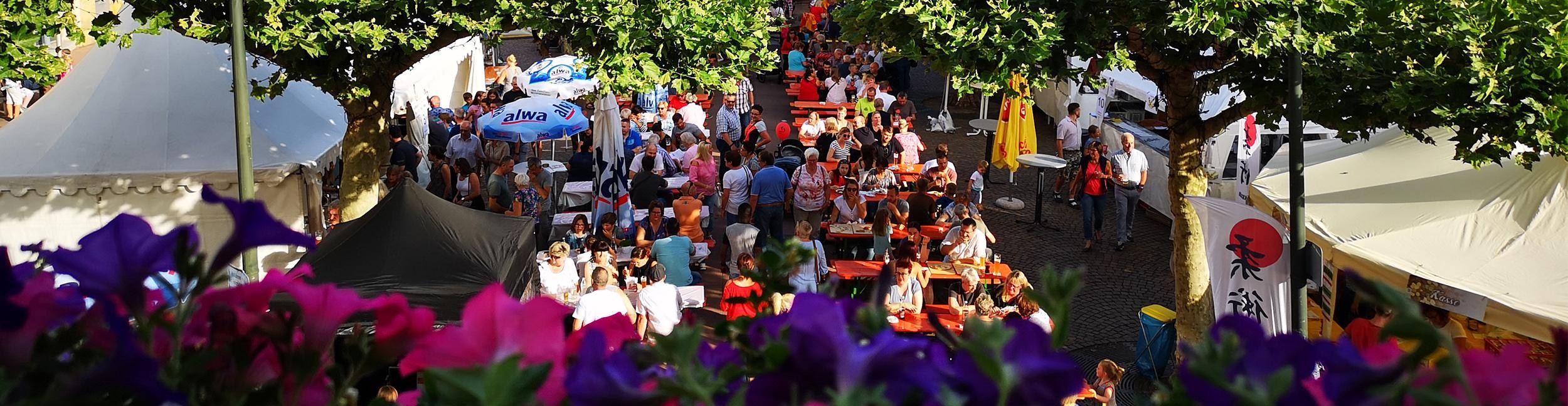 Stadtfest in Rastatt. Foto: Stadt Rastatt/Isabelle Joyon Menschen sitzen auf Bierbänken auf dem Marktfest beim Stadtfest
