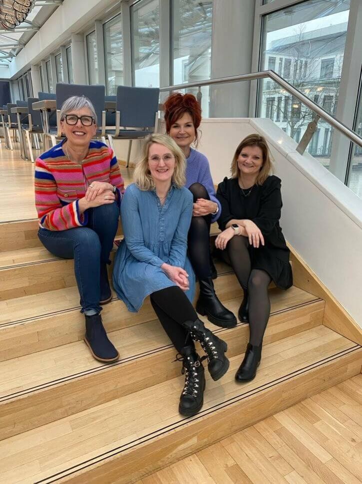 Vier Frauen sitzen auf Treppe