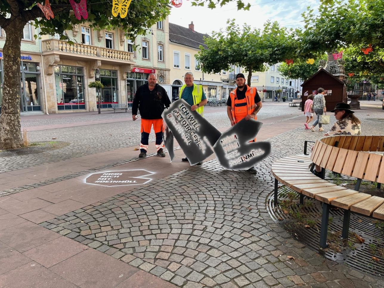 Städtische Mitarbeiter mit Schablone auf dem Marktplatz
