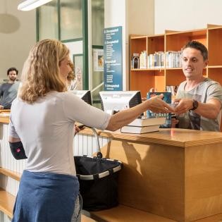 Foto: Andrea Fabry Frau gibt ein Buch in der Stadtbibliothek Rastatt ab