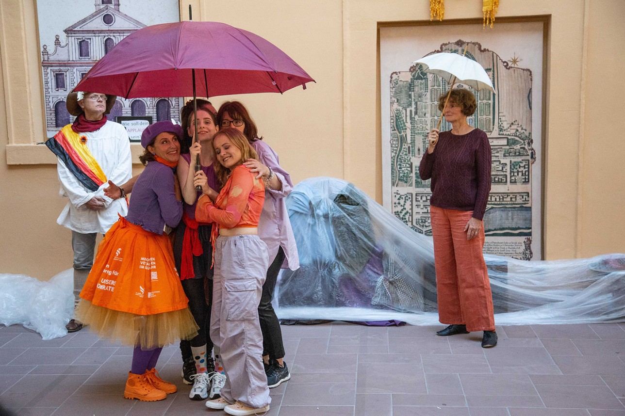 Des danseuses se tiennent sous un parapluie