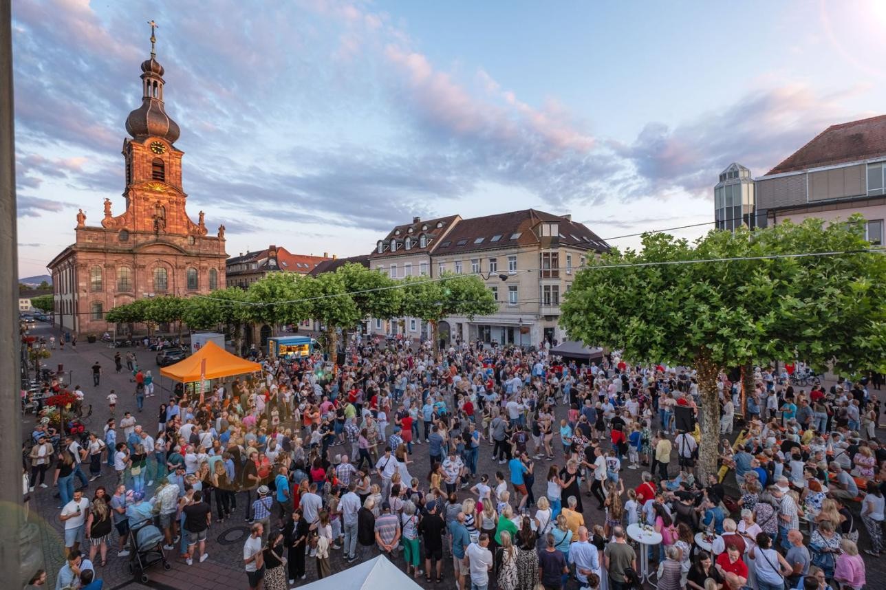 Ein letztes Mal unter Platanen tanzen: Die Sommeraktion der Stadt und der Tanzschule Müller endet am 12. September. Foto: Oliver Hurst Menschen tanzen auf dem Marktplatz