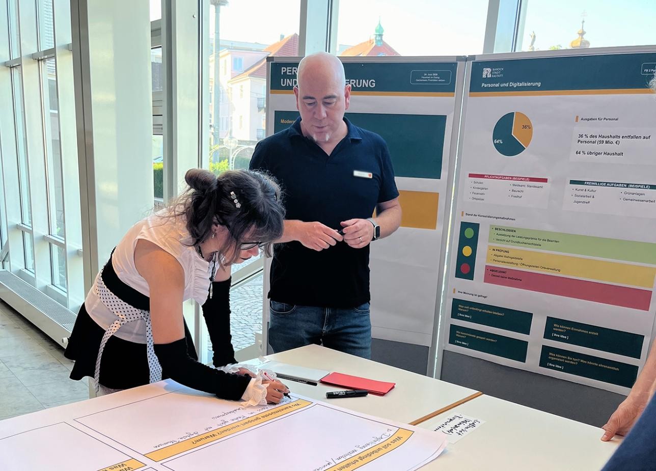 Rastatterinnen und Rastatter bringen bei der Infoveranstaltung ihre Ideen zum Rastatter Haushalt ein. Foto: Stadt Rastatt/Miriam Fischer Bürger diskutieren an Thementischen, wie die Stadt Rastatt sparen kann