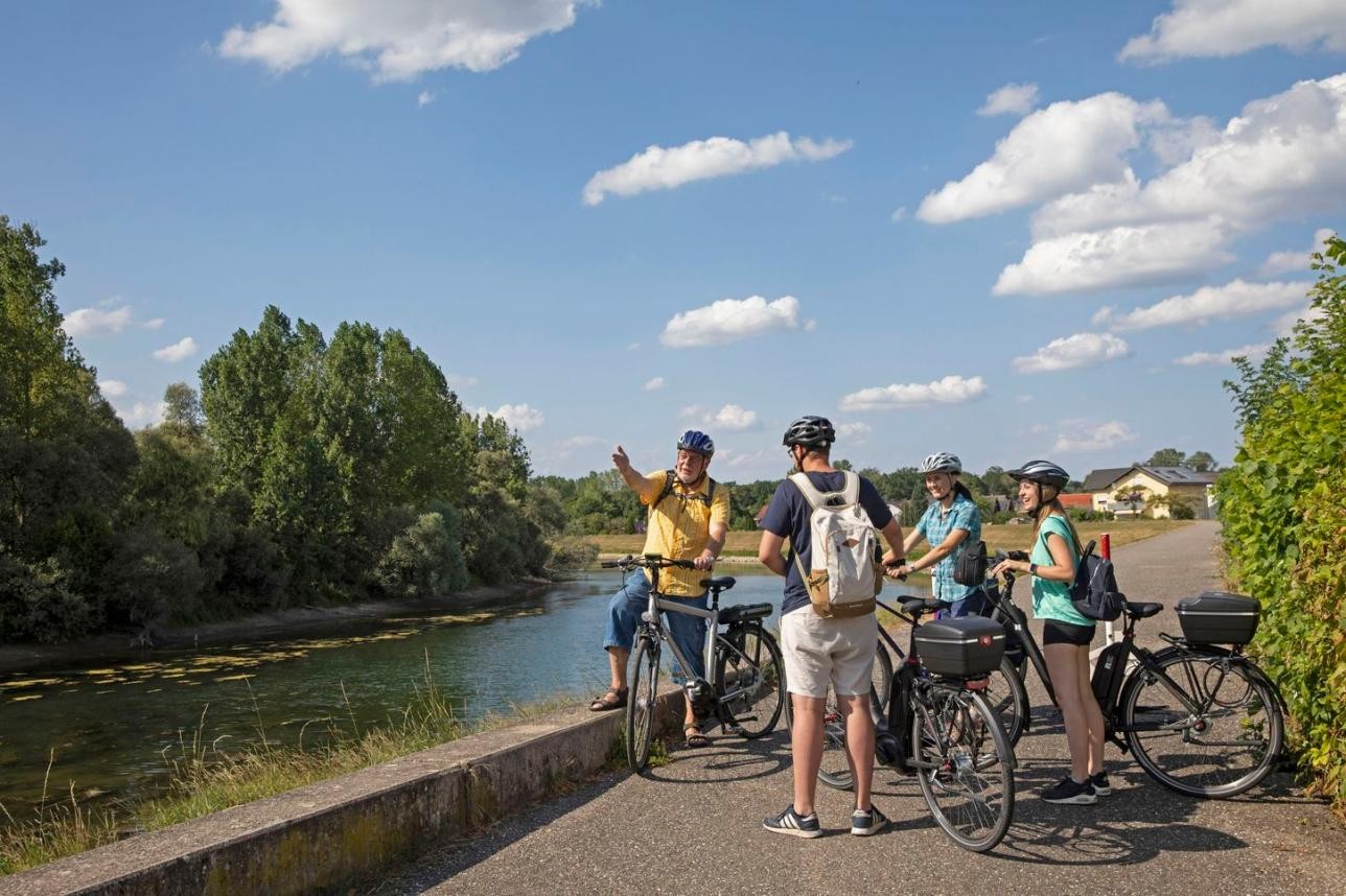 Mit dem Rad geht es für interessierte Teilnehmer am 28. Juni durch die Rastatter Auen des PAMINA-Rheinparks. Foto: Ulrike Klumpp Menschen mit Fahrrad am Rhein