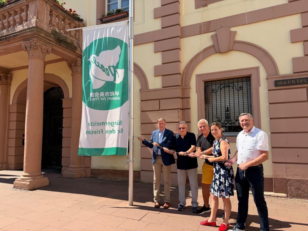 Gemeinsam hissen Jürgen Wahl, Herbert Köllner, Joachim Fischer, Oberbürgermeisterin Monika Müller und Roland Walter (von links) die Mayors-for-Peace-Flagge am Historischen Rathaus. Foto: Stadt Rastatt/Samira Kaiser Gemeinsam hissen Jürgen Wahl, Herbert Köllner, Joachim Fischer, Oberbürgermeisterin Monika Müller und Roland Walter (von links) die Mayors-for-Peace-Flagge am Historischen Rathaus.