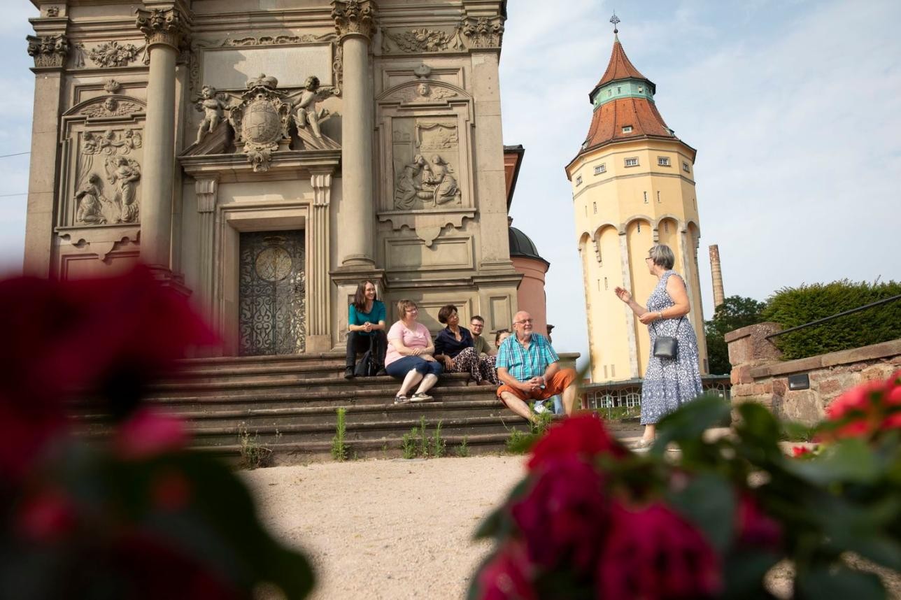 Rastatt bei einer geführten Tour neu entdecken. Foto: Ulrike Klumpp Menschen sitzen auf Treppe