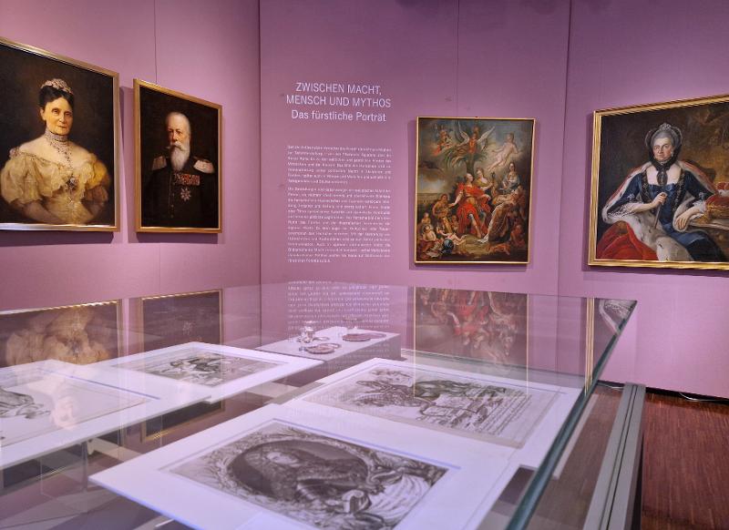 Blick in die Ausstellung mit Gemälden an den Wänden und Vitrinen mit Grafiken