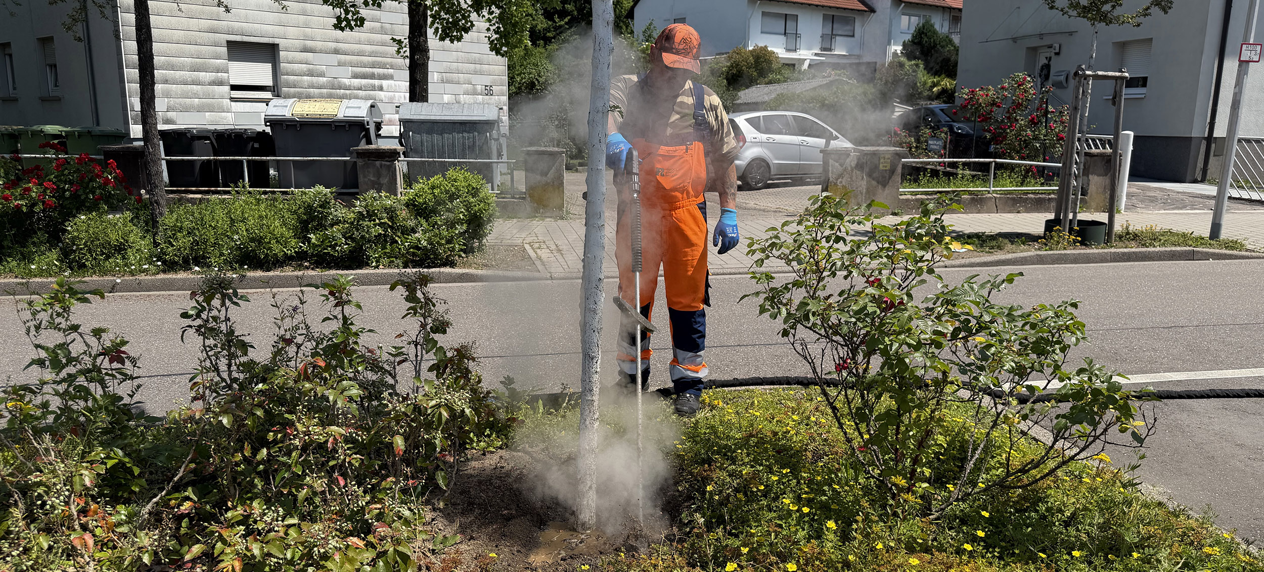Mann sprüht heißes Wasser in die Erde