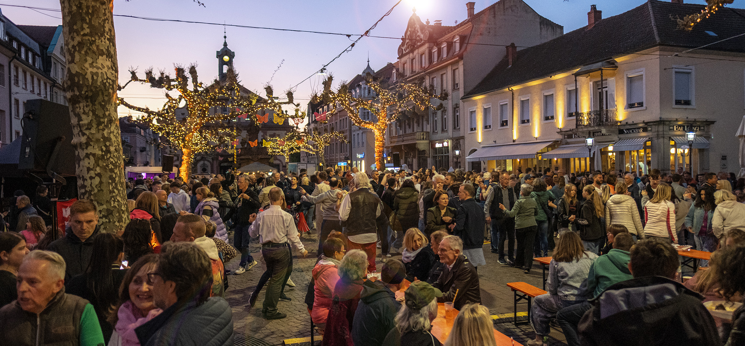 Viele Menschen tanzen auf dem Marktplatz in Rastatt bei "Tanz unter den Platanen"