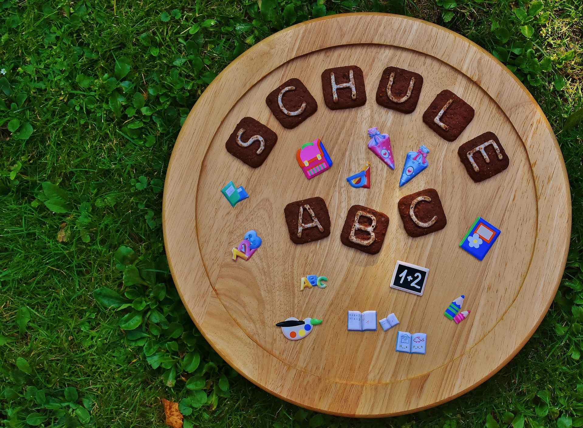 Cercle en bois avec des lettres et des symboles indiquant "école - ABC
