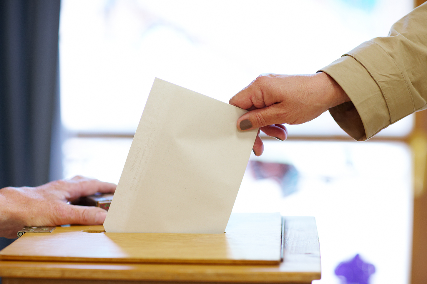 Frau wirft Stimmzettel in Wahlurne